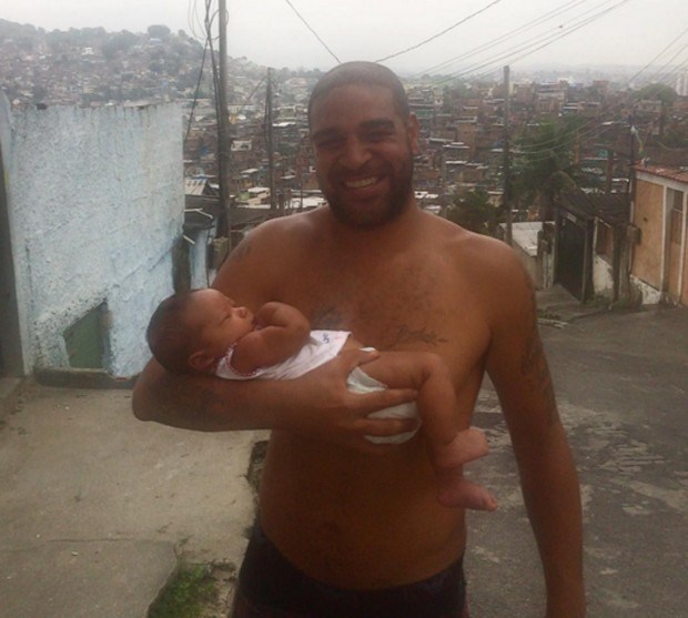 故郷ブラジル・リオデジャネイロで現地の子供を抱きかかえるアドリアーノ