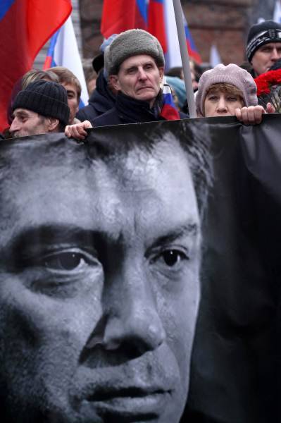 ボリス・ネムツォフ氏の遺影を掲げてデモに参加するロシアの民衆